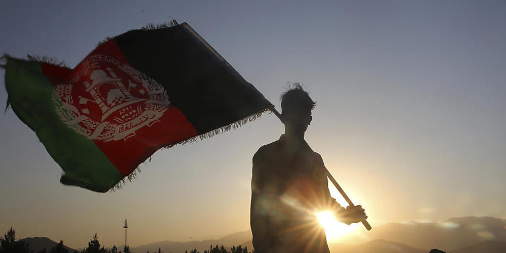 dpatopbilder - ARCHIV - Ein Mann schwenkt eine afghanische Nationalflagge. Foto: Rafiq Maqbool/AP/dpa