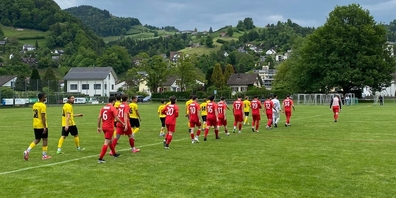 Die Spieler des FC Uznach (ganz rot) und des FC Wattwil Bunt 1929 (gelb-schwarz) beim Einlaufen auf dem Sportplatz Grüenau.
