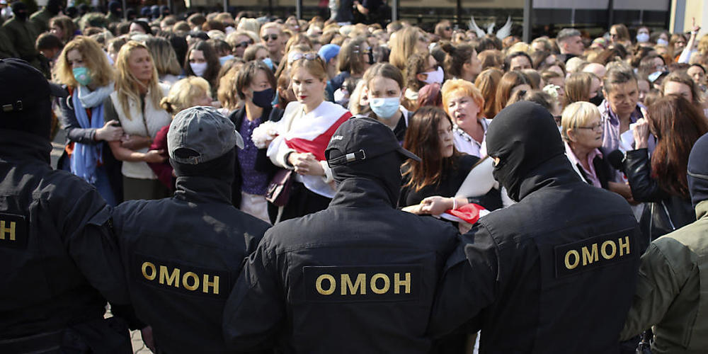 Polizisten der Spezialeinheit OMON stehen bei einem Protest gegen die Ergebnisse der belarussischen Präsidentenwahl vor den Demonstrantinnen. Foto: -/Tut.by via AP/dpa