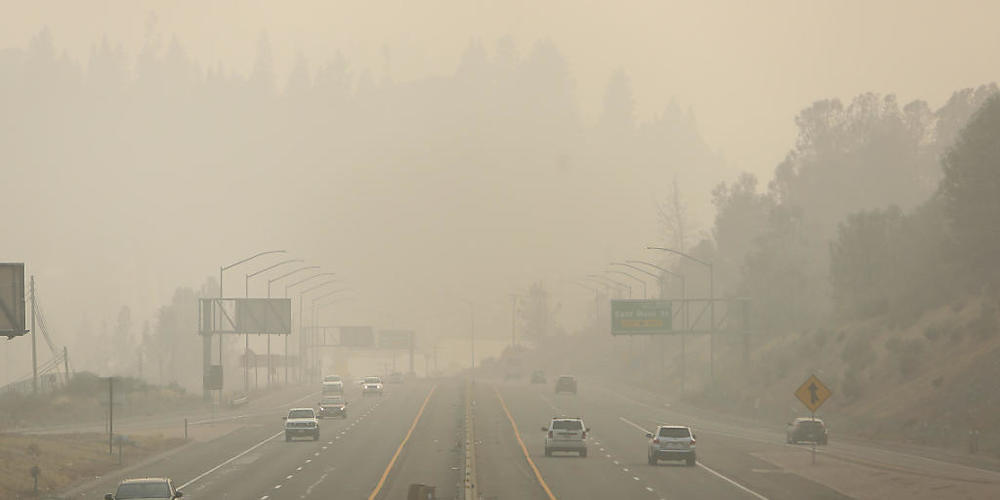 Autos fahren auf der Golden Center Autobahn durch dichten Rauch, der sich von den Waldbränden an der Westküste der USA ausbreitet. Foto: Elias Funez/The Union/AP/dpa - ACHTUNG: Nur zur redaktionellen Verwendung und nur mit vollständiger Nennung de...