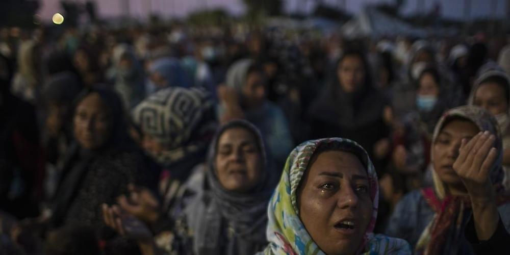 dpatopbilder - Migranten beten auf der Straße in der Nähe der Stadt Mytilini auf der Insel Lesbos. Nach dem Großbrand im Flüchtlingslager Moria auf Lesbos bleibt die Lage auch nach Öffnung erster Ersatz-Unterkünfte angespannt. Foto: Petros Giannak...