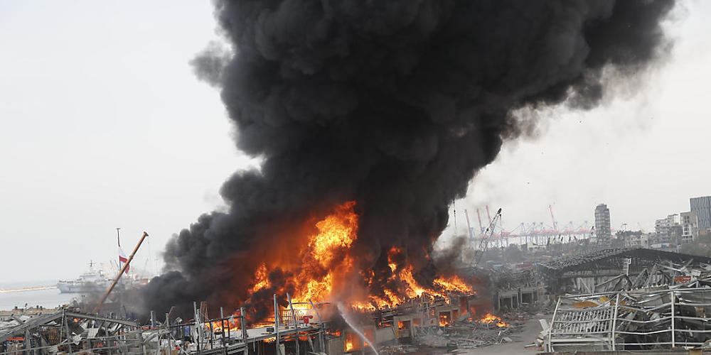 Rettungskräfte löschen ein Feuer, das im Hafen von Beirut brennt. Mehr als einen Monat nach der verheerenden Explosion in Beirut ist im Hafen der libanesischen Hauptstadt erneut ein großes Feuer ausgebrochen. Foto: Hussein Malla/AP/dpa