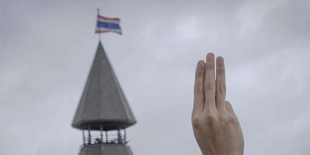 ARCHIV - Ein pro-demokratischer Demonstrant erhebt während einer Demonstration im Sanam-Luang-Park drei Finger als Symbol des Widerstands. Foto: Wason Wanichakorn/AP/dpa