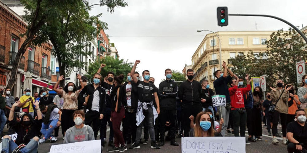 Demonstranten sitzen auf einer Strasse im Stadtbezirk Villa de Vallecas. Tausende Menschen haben in Madrid gegen die Abriegelungen von mehreren einkommensschwachen Gebieten der spanischen Hauptstadt zur Eindämmung der Corona-Pandemie protestiert. ...