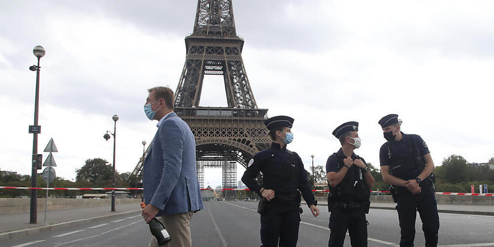 Französische Polizisten sichern das Gebiet um den Eiffelturm. Die Pariser Polizei hat nach einer Bombendrohung das Gebiet um den Eiffelturm evakuiert. Foto: Michel Euler/AP/dpa
