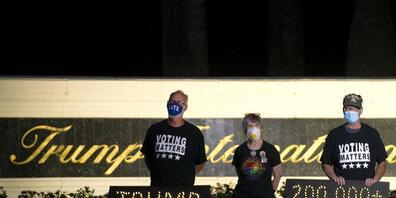 Die Demonstranten Mark Beaumont (l-r), Joyce Brown und Bruce Brown halten in der Nähe des Trump International Golf Club eine Mahnwache ab. In den USA sind inzwischen fast 200 000 Menschen nach einer Corona-Infektion gestorben. Foto: Meghan Mccarth...