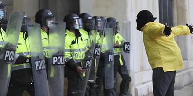 Ein Demonstrant steht während eines Protests gegen die Regierung vor Polizisten. Foto: Fernando Vergara/AP/dpa