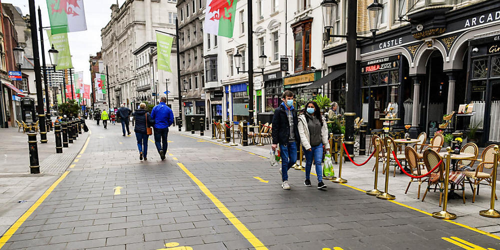 dpatopbilder - Nachdem die walisische Regierung für drei weitere Gebiete von Wales aufgrund steigender Corona-Zahlen lokale Lockdowns angeordnet hat, tragen die Menschen in Cardiff Gesichtsmasken. Foto: Ben Birchall/PA Wire/dpa