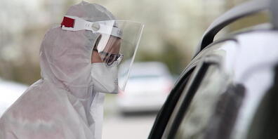 ARCHIV - Ein medizinischer Mitarbeiter im Schutzanzug und mit Gesichtsschutz nimmt in einem mobilen diagnostischen Labor in Warschau Proben von einem Patienten entgegen. Foto: Leszek Szymanski/PAP/dpa
