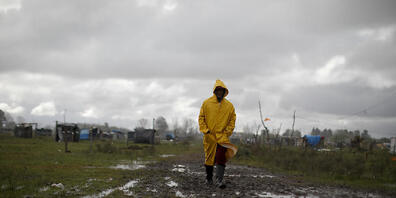 dpatopbilder - Ein Mann geht durch eine informelle Siedlung in Buenos Aires. Foto: Natacha Pisarenko/AP/dpa