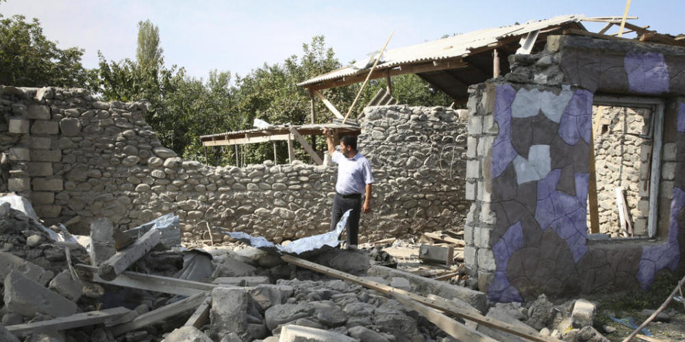 Ein Mann steht in den Ruinen eines Hauses, das angeblich während der Kämpfe beschädigt wurde. Foto: Aziz Karimov/AP/dpa