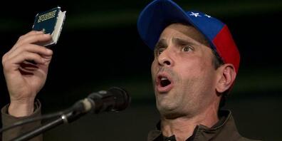 ARCHIV - Henrique Capriles, Oppositionspolitiker in Venezuela, spricht zu seinen Anhängern und hält dabei eine Miniaturausgabe der Verfassung von Venezuela in die Höhe. Foto: Ariana Cubillos/AP/dpa