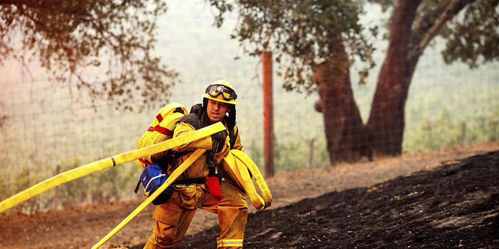 Ein Feuerwehrmann im Einsatz gegen das «Glass Fire», das in einem Weingut brennt. Foto: Noah Berger/AP/dpa