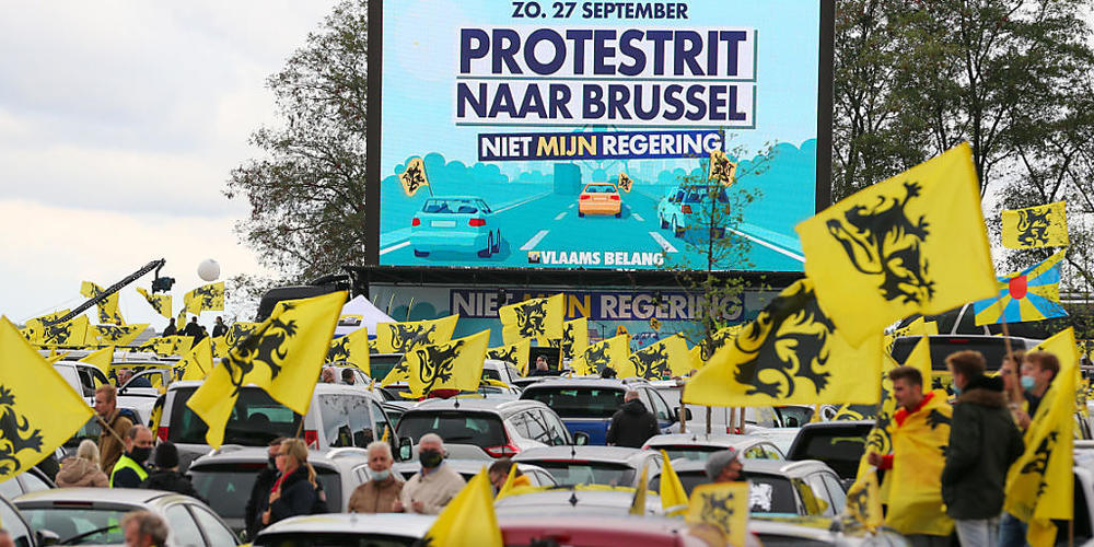Demonstranten halten zwischen ihren Autos flämische Flaggen während des Protestes der rechtspopulistischen Regionalpartei Vlaams Belang gegen die Regierung. Foto: Nicolas Maeterlinck/BELGA/dpa