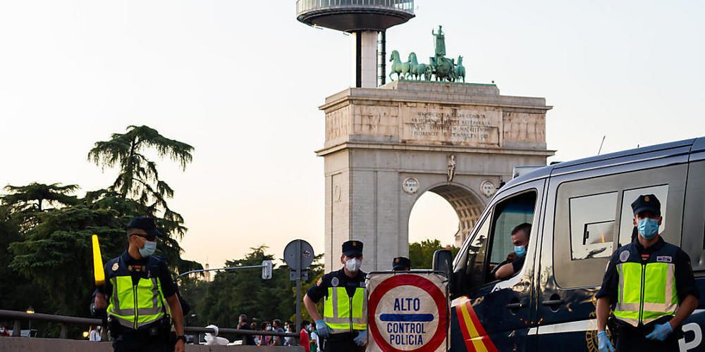 Polizisten stehen an einem Kontrollpunkt in Madrid. Die Justiz hat die umstrittene Zwangsabriegelung des Corona-Hotspots Madrid durch die spanische Zentralregierung gekippt. Foto: Diego Radames/SOPA Images via ZUMA Wire/dpa