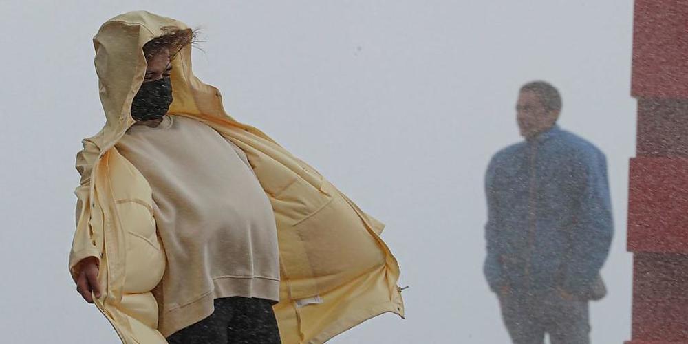 dpatopbilder - Eine Frau kämpft bei Regen gegen den starken Wind in Nizza an. Nach Unwettern und Überschwemmungen in der Region der südfranzösischen Metropole werden nach Medienberichten mindestens neun Menschen vermisst. Foto: Valery Hache/AFP/dpa