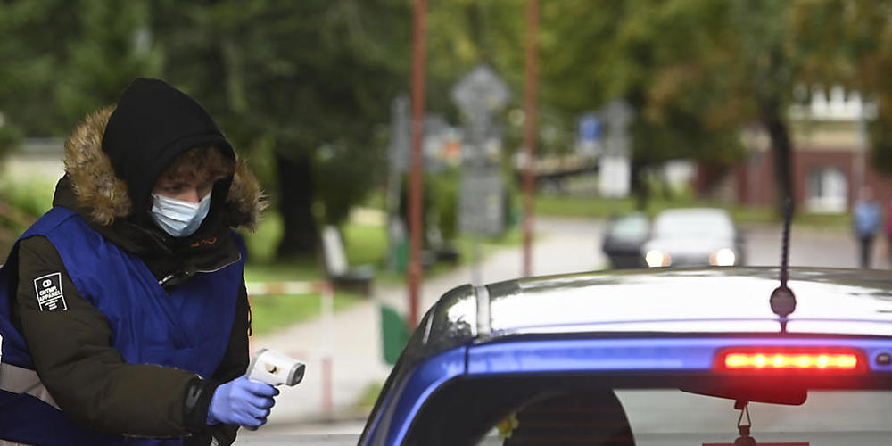 ARCHIV - Eine Mitarbeiterin misst am Eingang zum Universit&#8240;tsklinikum TrencÌn, Slowakei, die K&#710;rpertemperatur einer Frau im Auto. Foto: Radovan Stoklasa/TASR/dpa