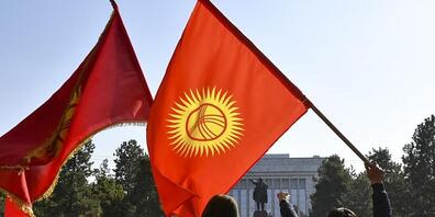 Die Demonstranten schwenken der kirgisischen Fahnen, während sie auf die Rede des kirgisischen Premierministers Schaparow vor dem Regierungsgebäude warten. In Kirgistan ist nach massiven Protesten der Oppositionelle Schaparow vom Parlament als neu...