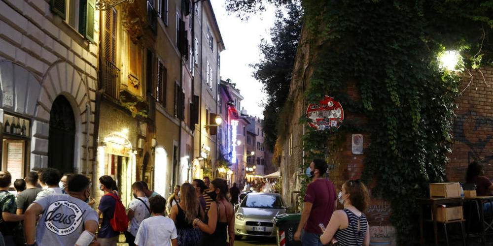 ARCHIV - Gäste stehen mit Mundschutzen vor einem Restaurant an. Italiens Regierung bereitet nach Medienberichten eine erneute Verschärfung der Anti-Corona-Maßnahmen vor, um den steilen Anstieg der Ansteckungszahlen zu bremsen. Foto: Cecilia Fabian...