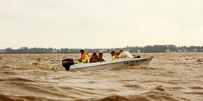 Rettungskräfte fahren mit einem Boot über überflutetes Gebiet in Quang Binh. Foto: Nguyen Van Ty/VNA/AP/dpa