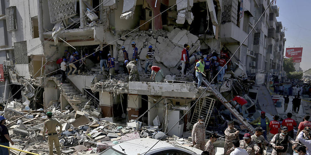 dpatopbilder - Rettungskräfte und Helfer suchen nach Überlebenden inmitten der Trümmer eines nach einer Explosion beschädigten Gebäudes. Foto: Fareed Khan/AP/dpa