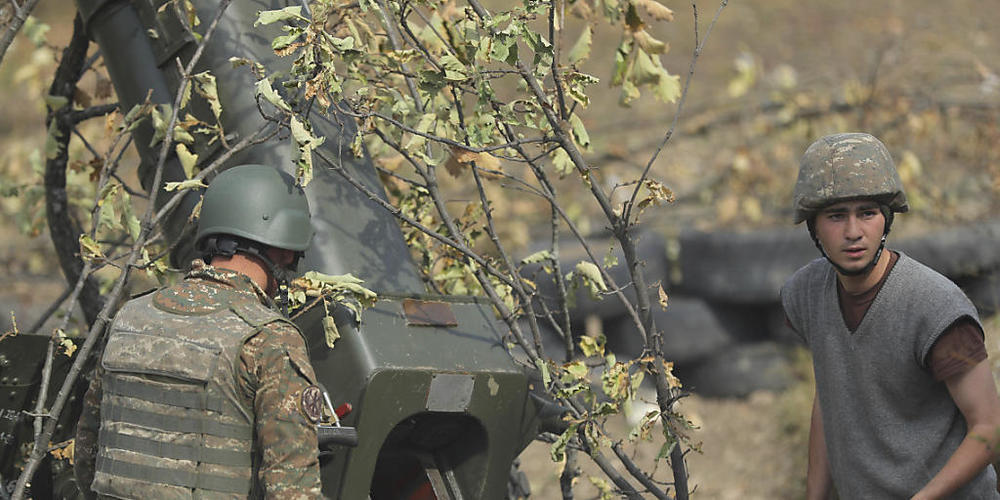 Armenische Soldaten feuern an der Front eine Artilleriewaffe ab. Im blutigen Konflikt um die Südkaukasusregion Berg-Karabach steigt ungeachtet des Ringens um eine Waffenruhe die Zahl der Toten massiv. Foto: Sipan Gyulumyan/Armenian Defense Ministr...