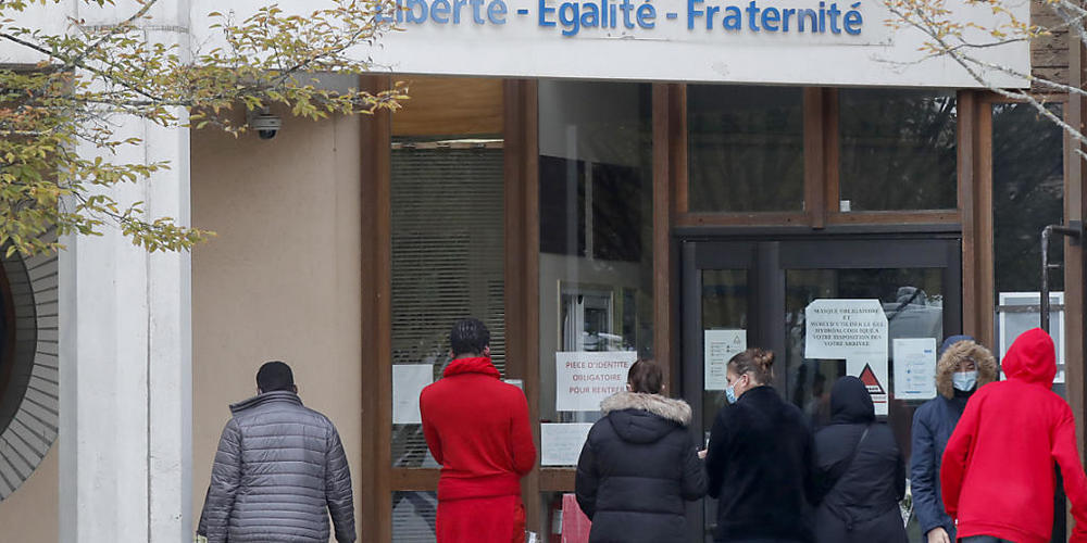 Schüler gedenken vor einer Schule, auf der der Schriftzug «Liberté - Egalité - Fraternité» (Freiheit - Gleichheit - Brüderlichkeit) zu lesen ist, einem Lehrer, der bei einer mutmaßlich terroristisch motivierten Tat ermordet wurde. Foto: Michel Eul...