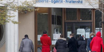 Schüler gedenken vor einer Schule, auf der der Schriftzug «Liberté - Egalité - Fraternité» (Freiheit - Gleichheit - Brüderlichkeit) zu lesen ist, einem Lehrer, der bei einer mutmaßlich terroristisch motivierten Tat ermordet wurde. Foto: Michel Eul...