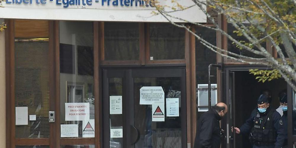 Blumen liegen vor der Mittelschule in Conflans-Saint-Honorine. Foto: Bertrand Guay/AFP/dpa
