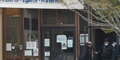 Blumen liegen vor der Mittelschule in Conflans-Saint-Honorine. Foto: Bertrand Guay/AFP/dpa