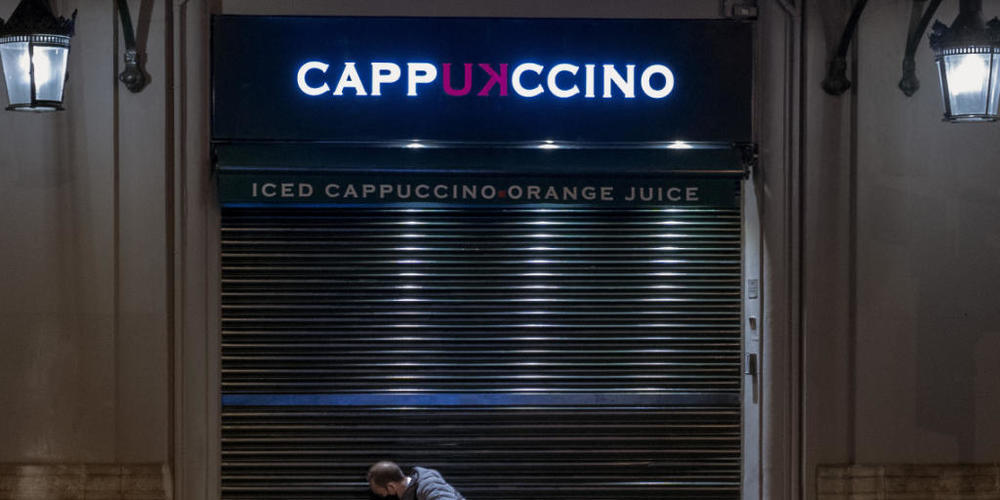 dpatopbilder - Ein Angestellter schließt ein Café vor der Sperrstunde in Barcelona. Foto: Emilio Morenatti/AP/dpa