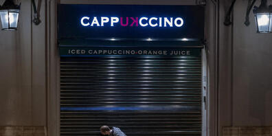 dpatopbilder - Ein Angestellter schließt ein Café vor der Sperrstunde in Barcelona. Foto: Emilio Morenatti/AP/dpa