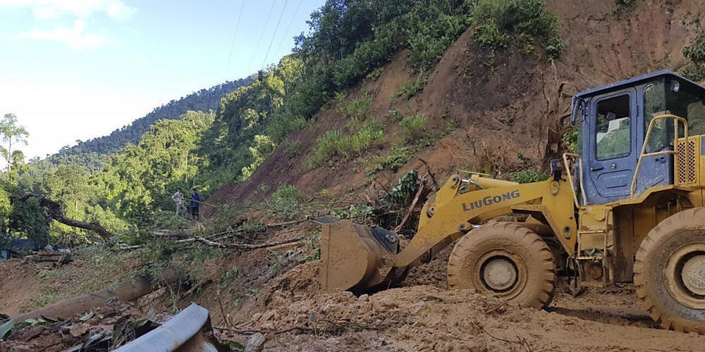 Ein Bulldozer räumt eine durch einen Erdrutsch beschädigte Straße. Zwei durch den Taifun «Molave» verursachte Erdrutsche haben in Vietnam mindestens 13 Menschen getötet. Foto: Bui Van Lanh/VNA/dpa