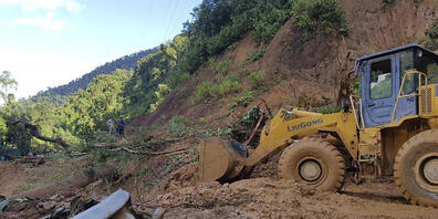 Ein Bulldozer räumt eine durch einen Erdrutsch beschädigte Straße. Zwei durch den Taifun «Molave» verursachte Erdrutsche haben in Vietnam mindestens 13 Menschen getötet. Foto: Bui Van Lanh/VNA/dpa