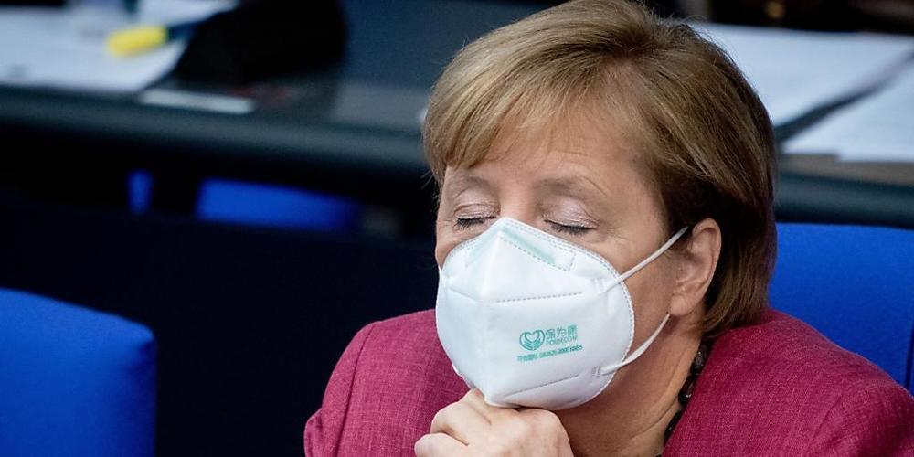 Bundeskanzlerin Angela Merkel (CDU) verfolgt mit geschlossenen Augen und Mund-Nasenbedeckung die Sitzung des Bundestages. Sie hatte vorher eine Regierungserklärung zur Bewältigung der Corona-Pandemie abgegeben. Foto: Kay Nietfeld/dpa