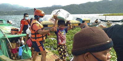 HANDOUT - Auf diesem von der philippinischen Küstenwache zur Verfügung gestellten Foto werden Familien von Mitgliedern der philippinischen Küstenwache auf sichereren Boden in der Provinz Camarines Sur im Osten der Philippinen gebracht, während sie...