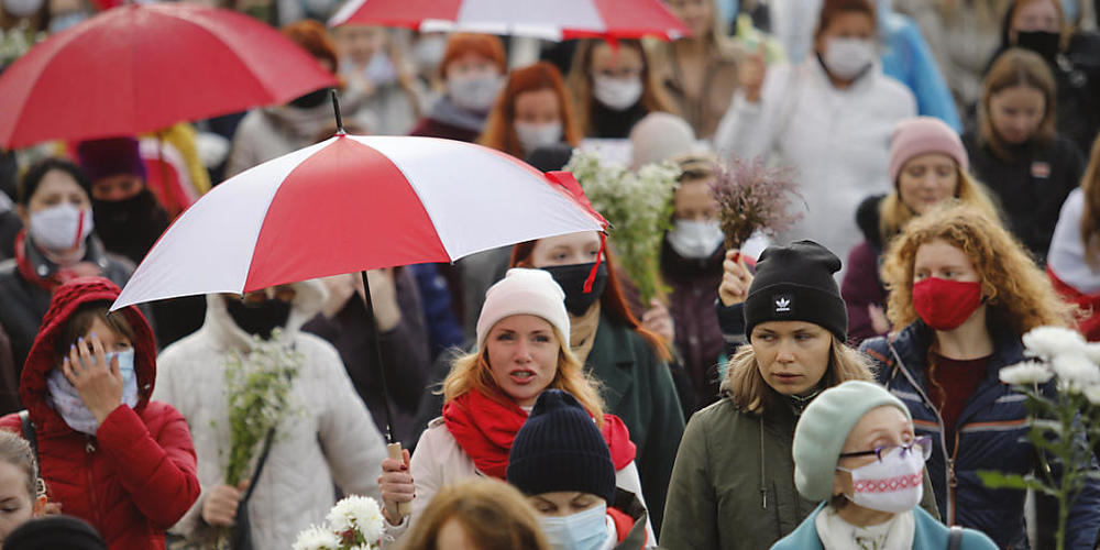 Belarussische Frauen mit Regenschirmen in den Farben der alten belarussischen Nationalflagge. Foto: -/AP/dpa
