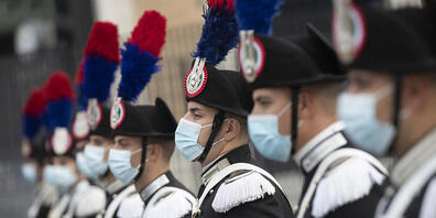 Eine Gruppe italienischer Carabinieri trägt während der Feierlichkeiten zum Tag der Streitkräfte Mund-Nasen-Schutz. Foto: Alessandra Tarantino/AP/dpa