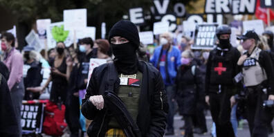 dpatopbilder - Eine Frau trägt während einer Demonstration in Portland für die Auszählung aller Stimmen im Rahmen der Präsidentschaftswahl eine Waffe. Foto: Marcio Jose Sanchez/AP/dpa