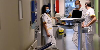 Krankenhauspersonal mit Mund-Nasen-Bedeckung bereitet in Bonheiden die Öffnung einer zusätlich eingerichteten Intensivstation vor. Foto: Dirk Waem/BELGA/dpa