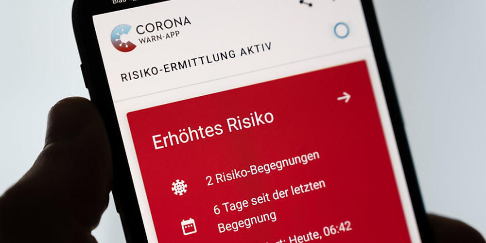 Ein Mann hält ein Smartphone in der Hand, auf dem die Corona-Warn-App der Bundesregierung ein erhöhtes Risiko anzeigt. Foto: Marius Becker/dpa