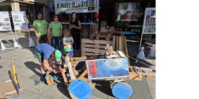 Beim Traktor Fridolin (links) und Felix (rechts), beide mit grünen Dächlikappen. Angehängt ist eine Walze.