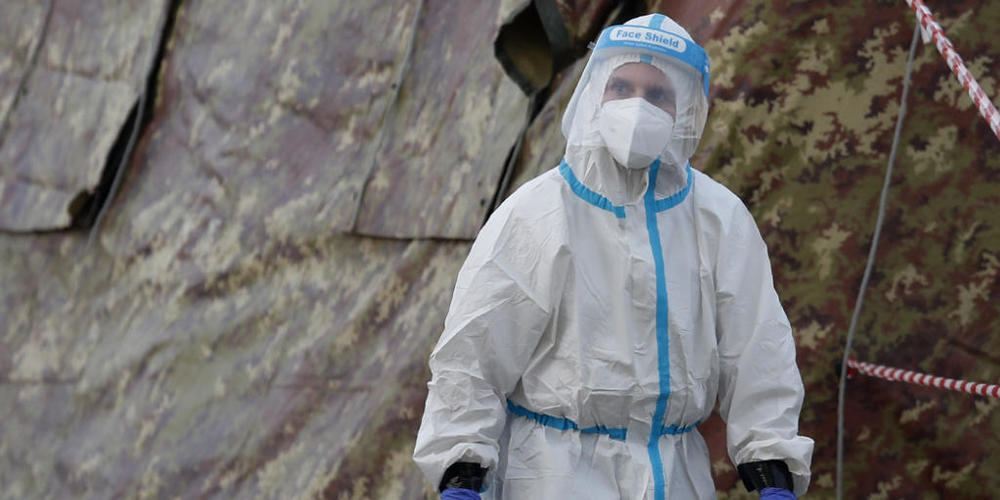Ein Mitarbeiter des Gesundheitswesens in Schutzanzug arbeitet an einem Kontrollpunkt in Mailand, der nach dem Anstieg der Corona-Fallzahlen eingerichtet wurde, um die Notfallstationen der Krankenhäuser zu entlasten. Foto: Antonio Calanni/AP/dpa