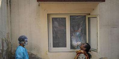 dpatopbilder - Ein mit einem Schutzanzug bekleideter Mitarbeiter des Gesundheitswesens nimmt bei einer Frau in einem Covid-19-Testzentrum im indischen Neu Delhi eine Nasenabstrichprobe. Foto: Altaf Qadri/AP/dpa
