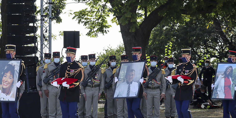dpatopbilder - Die Republikanische Garde trägt die Porträts der Opfer Nadine Devillers (l-r), Vincent Loques und der Brasilianerin Simone Barreto Silva, im Rahmen einer Gedenkzeremonie nach dem tödlichen Messerangriff in Nizza. Foto: Valery Hache/...