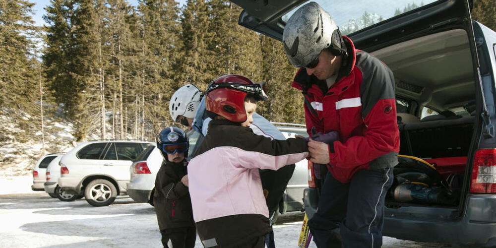 Eine Familie macht sich in Graubünden bereit fürs Skifahren. Schon ab dem nächsten Jahr sollen Bündner Familien von deutlichen Steuersenkungen profitieren. (Archivbild)