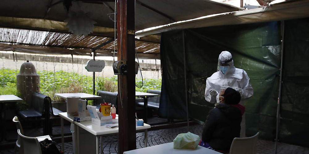 Eine Frau wird im Außenbereich eines geschlossenen Restaurants auf das Coronavirus getestet. Foto: Alessandra Tarantino/AP/dpa
