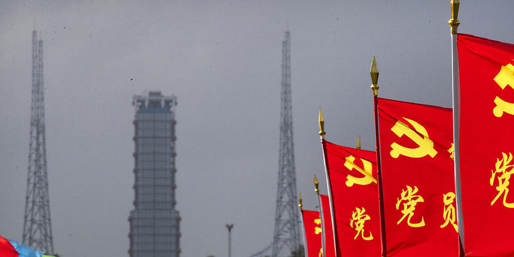 Flaggen der Kommunistischen Partei Chinas an der Straße zum Startplatz des Kosmodroms Wenchang. Foto: Mark Schiefelbein/AP/dpa