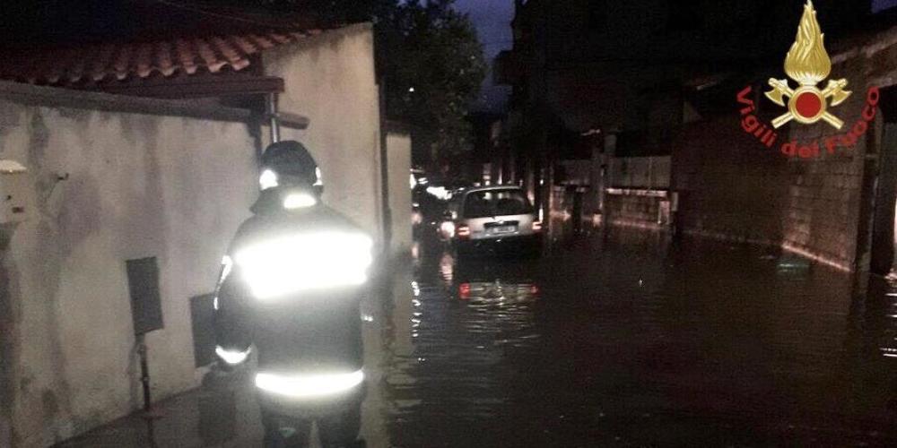 HANDOUT - Ein Feuerwehrmann steht in einer überfluteten Straße auf Sardinien. Auf der italienischen Mittelmeerinsel hat ein Unwetter schwere Schäden angerichtet. Foto: Vigili del Fuoco/dpa - ACHTUNG: Nur zur redaktionellen Verwendung im Zusammenha...