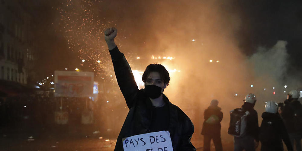 Ein Teilnehmer einer Demonstration hält während eines Protestes gegen ein neues Sicherheitsgesetz ein Schild mit der Aufschrift «Land der Polizeirechte» in der Hand. Foto: Francois Mori/AP/dpa